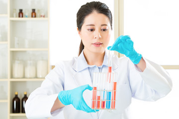 Asian female scientist researcher observing indicator color shif