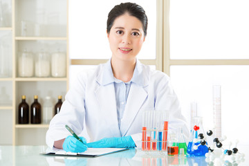 Asian female scientist recording research data with smile face