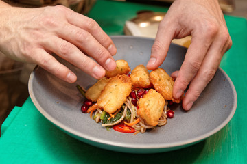 Chef is cooking a fusion cuisine appetizer