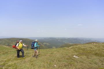 Fototapeta premium Summer hiking in the mountains with a backpack .