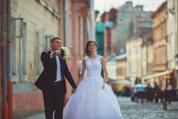Fototapeta premium gorgeous wedding couple enjoys a Sunny day in the old town with architecture