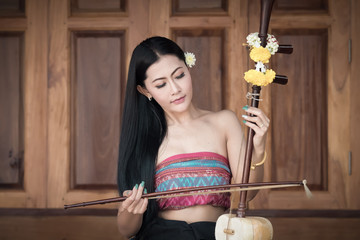Beautiful girl in Thai traditional costume with a fiddle.
