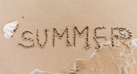 summer text background written on sand and piece of sea.