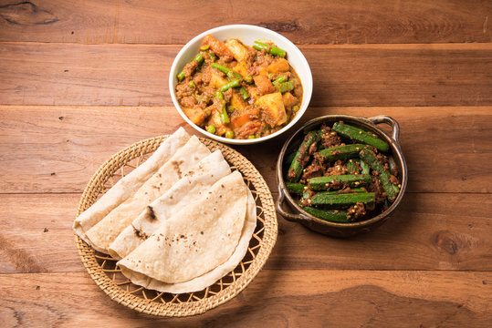 bhindi masala or bhendi masala or ladies finger fry with mixed veg in red curry with indian roti / chapati / fulka / paratha / indian bread, indian spicy food