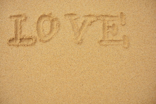 Love You und Herz in den sonnigen Strandsand geschrieben 