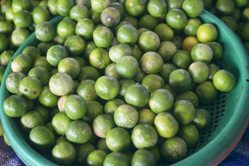 green lime in a basket at thai market store,light and shadow,selective focus,filtered image