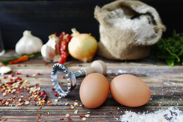 Making pasta ravioli on old wooden table with flour, eggs, kitch