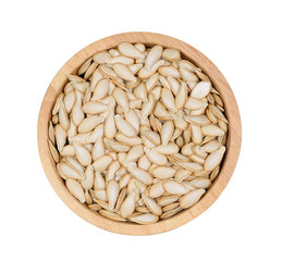 Top view pumpkin seeds in a wooden bowl on a white background