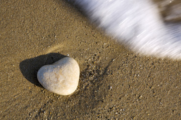 Heart shaped stone and a water wave.