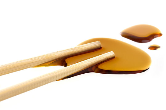 Soy sauce with chopsticks isolated on white