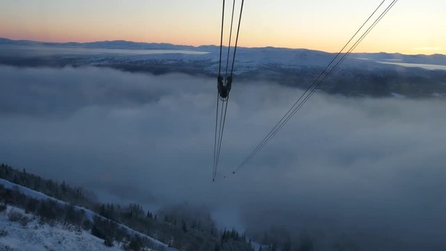 View from moving cabin on oncoming tower of cable car and setting sun. Sweden