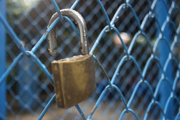 close up a key lock hook on iron wire gates and water drop of rain with blur background,selective focus,filtered image,light effect added