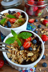 Berry crumble with oatmeal and almonds on wooden background