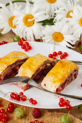 Homemade strudel with berries on wood