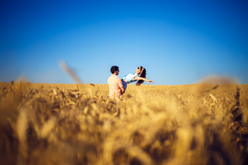 Fototapeta na wymiar Couple in love enjoying tender moments during sunset . Emotional concept of relationship with travel boyfriend and girlfriends relaxing together. guys are walking in wheat 