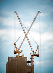 X in the city, Red Industrial Crane on Construction Site with rain clouds in morning sky, Concept image