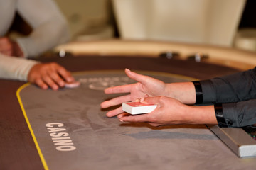 Hands with cards on poker table, selective focus