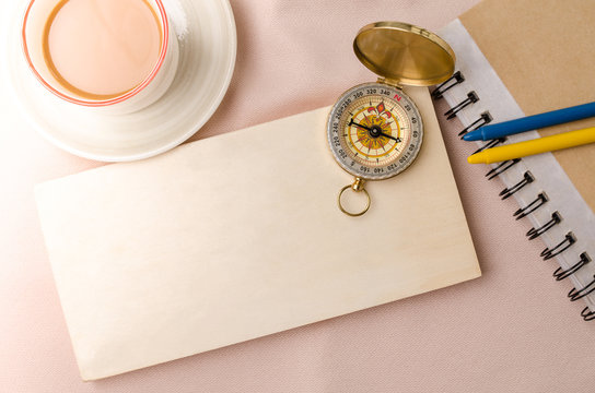 Blank wooden bord with vintage compass on fabric background. Top