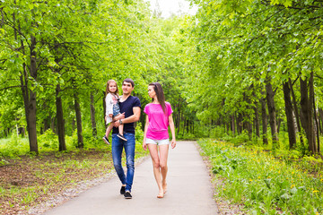 Obraz premium Father, daughter and mother walking outdoors. Happy family.