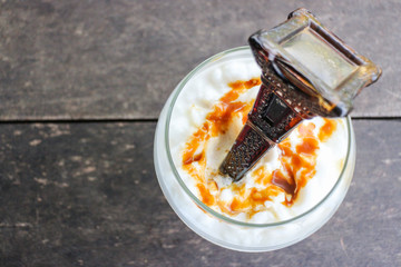 Caramel frappe coffee with syrup bottle at top