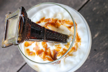 Caramel frappe coffee with syrup bottle at top