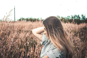 Beautiful and young girl in a man's shirt standing in the field.
shirt for the girl. Nature. Wind inflates hair.