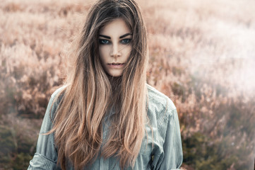Beautiful and young girl in a man's shirt standing in the field. Fog.
shirt for the girl. Nature. Wind inflates hair. - 115459834