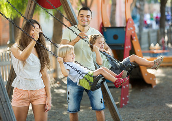 Plakat Daughters on swings with parents
