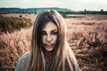 Beautiful and young girl in a man's shirt standing in the field. Halloween girl zombie.
shirt for the girl. Nature. Wind inflates hair.