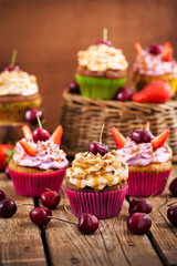 Delicious cupcakes decorated with caramel and fresh berries