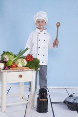One little boy as chef cook making salad, cooking with vegetable