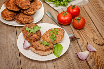 grilled pork cutlets. Fried pork burgers with tomatoes on the wooden background