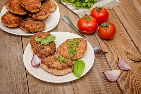 grilled pork cutlets. Fried pork burgers with tomatoes on the wooden background