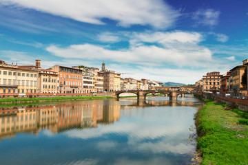 Fototapeta na wymiar old town, bridges and river Arno reflecting in water at summer day, Florence, Italy