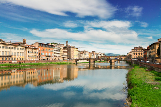 old town, bridges and river Arno reflecting in water at summer day, Florence, Italy