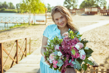 blonde girl with bouquet in a blue dress