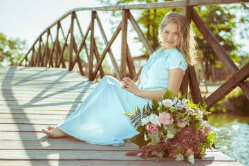 blonde girl with bouquet in a blue dress