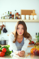 Young woman standing near desk in the kitchen