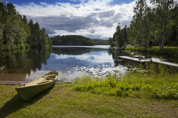 Boat on the bank of the forest lake. Finland..