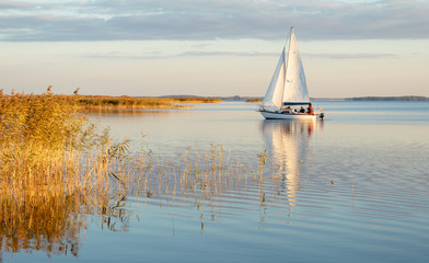 Sailing boat on a calm lake with reflection