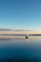 Sailing boat on a calm lake with reflection