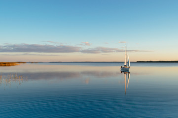 Sailing boat on a calm lake with reflection