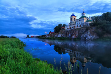 Fototapeta na wymiar Russian orthodox church. Fog over river near the cliff and church. Ural, Chusovaya.