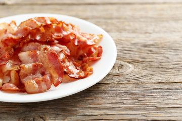Crispy strips of bacon on a grey wooden background