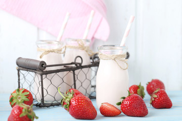 Strawberry yogurt in bottle on wooden table