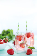 Fresh strawberry drink in bottle on wooden table