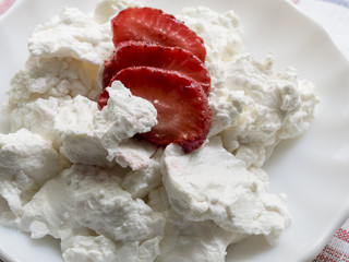 sliced strawberries are on the plate with cheese. close-up