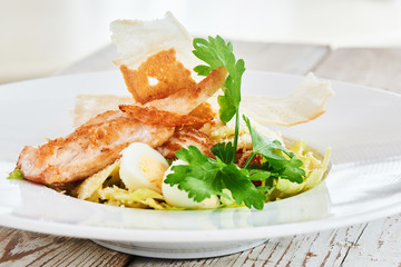 Chicken salad and boiled eggs served on a white plate