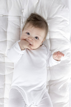 teething baby with hand in mouth
