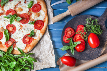 Pizza Margherita on dark wooden background